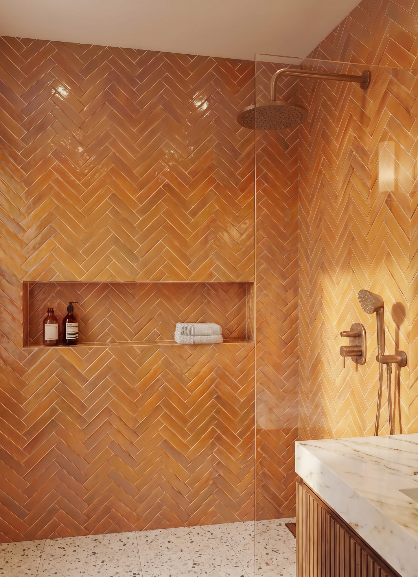Bathroom with orange herringbone tile pattern, shower area, and marble countertop.